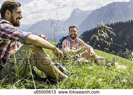 Stock Image - Male friends resting on hike, Tyrol, Austria. Fotosearch