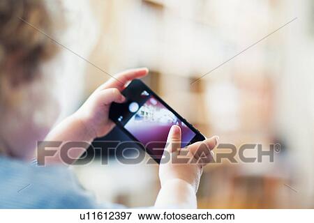 Male toddler playing with mobile phone View Large Photo Image Stock Photo - Male toddler playing with mobile phone. Fotosearch