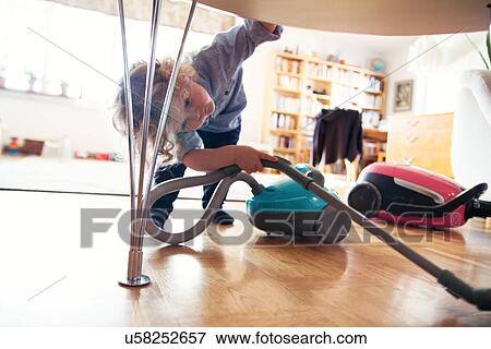 Male toddler vacuuming under table View Large Photo Image Stock Photo - Male toddler vacuuming under table. Fotosearch