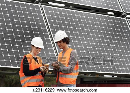 Stock Photo - Man and woman working on photo voltaic panels. Fotosearch