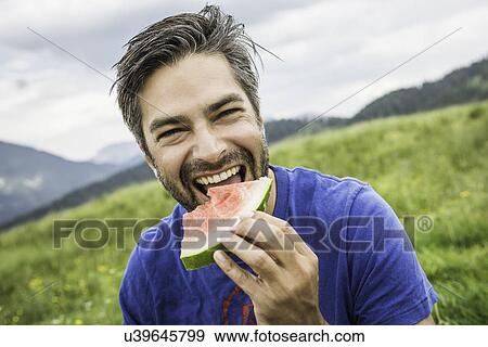 Man biting into watermelon View Large Photo Image Stock Photo - Man biting into watermelon. Fotosearch