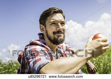 Stock Image - Man holding apple. Fotosearch