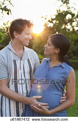 Man hugging pregnant woman, hands on stomach View Large Photo Image Stock Image - Man hugging pregnant woman, hands on stomach. Fotosearch