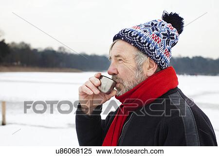 Stock Photography - Man outdoors having hot drink. Fotosearch