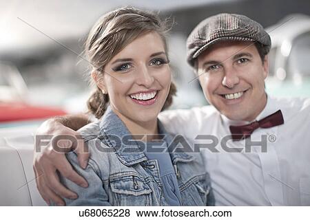Stock Photo - Man with arms around woman in back seat of convertible. Fotosearch