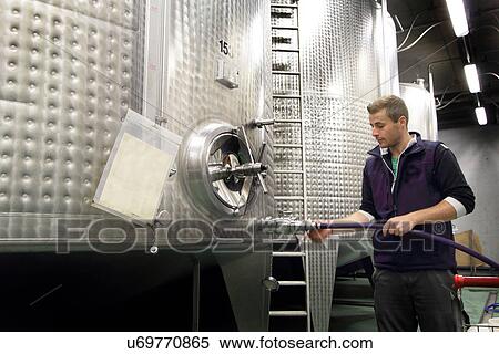 Man working in industrial wine cellar View Large Photo Image Stock Photography - Man working in industrial wine cellar. Fotosearch