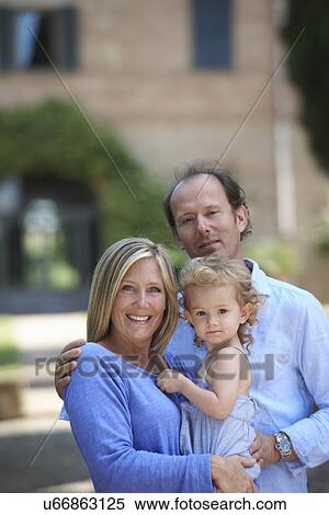 Mature couple standing in garden with toddler daughter View Large Photo Image Stock Photography - Mature couple standing in garden with toddler daughter. Fotosearch
