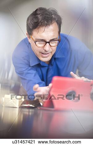 Mature man looking at digital tablet View Large Photo Image Stock Image - Mature man looking at digital tablet. Fotosearch