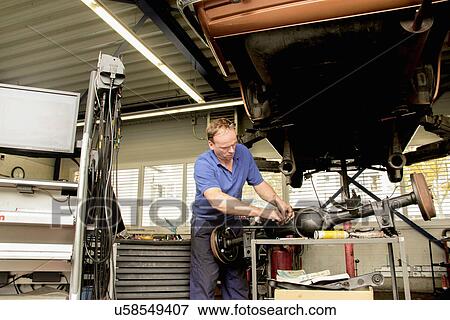 Mechanic repairing car in workshop View Large Photo Image Stock Photo - Mechanic repairing car in workshop. Fotosearch