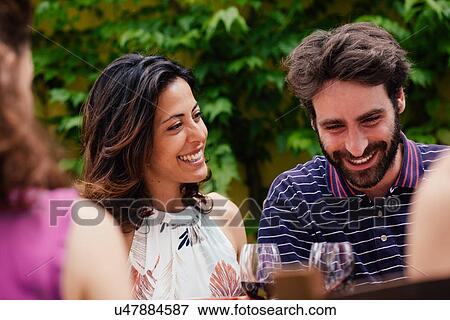Stock Photo - Mid adult couple at outdoor meal. Fotosearch