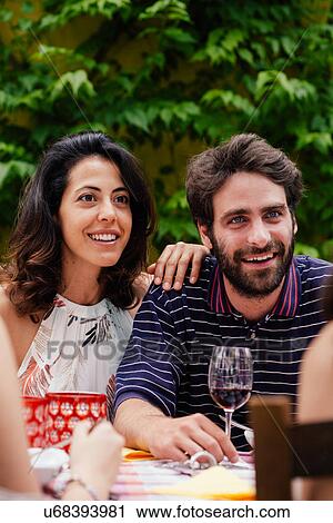 Mid adult couple listening to conversation at outdoor meal View Large Photo Image Stock Image - Mid adult couple listening to conversation at outdoor meal. Fotosearch