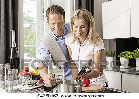 Mid adult couple preparing food View Large Photo Image Stock Image - Mid adult couple preparing food. Fotosearch