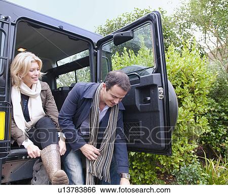 Stock Photograph - Mid adult couple preparing for country walk. Fotosearch