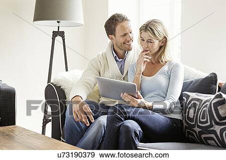 Mid adult couple using digital tablet View Large Photo Image Stock Photo - Mid adult couple using digital tablet. Fotosearch