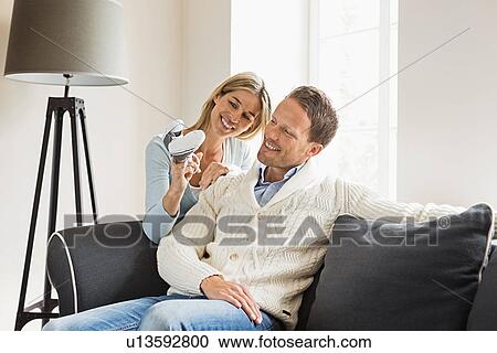 Mid adult couple, woman holding baby shoes View Large Photo Image Stock Image - Mid adult couple, woman holding baby shoes. Fotosearch