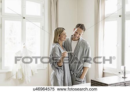 Stock Photography - Mid adult couple, woman holding pregnancy test. Fotosearch