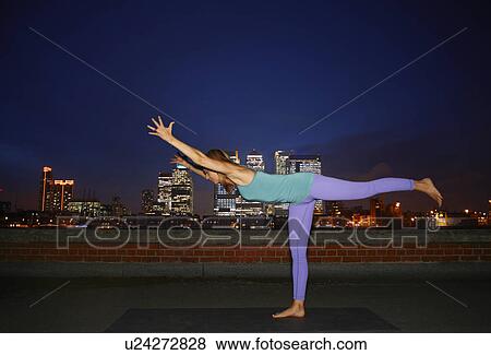 Mid adult woman practicing yoga on city rooftop View Large Photo Image Stock Photo - Mid adult woman practicing yoga on city rooftop. Fotosearch