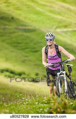 Mid adult woman with mountain bike View Large Photo Image Stock Photo - Mid adult woman with mountain bike. Fotosearch