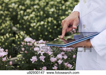 Mid section of scientist using digital tablet View Large Photo Image Stock Photo - Mid section of scientist using digital tablet. Fotosearch