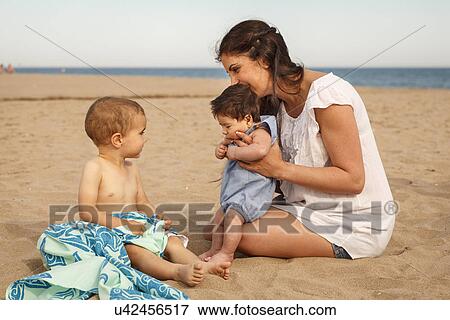 Mother and babies sitting on beach View Large Photo Image Stock Photo - Mother and babies sitting on beach. Fotosearch