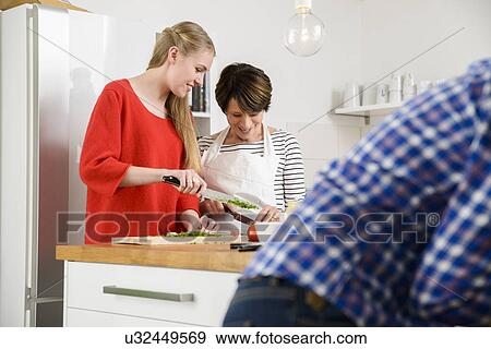 Stock Photo - Mother and daughter preparing food in kitchen. Fotosearch