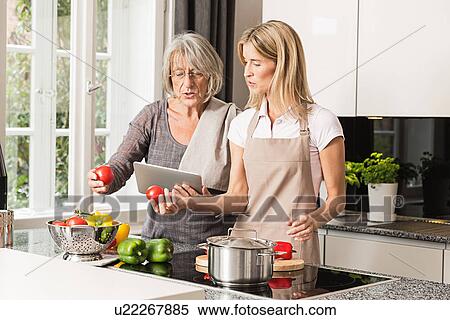 Mother and daughter preparing food View Large Photo Image Stock Photography - Mother and daughter preparing food. Fotosearch