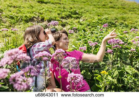 Stock Image - Mother and daughter with binoculars, Tyrol, Austria. Fotosearch