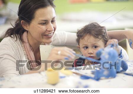 Stock Image - Mother and toddler painting in art class. Fotosearch