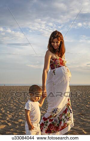 Picture - Mother and toddler walking along beach, holding hands. Fotosearch