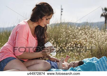 Mother applying suncream to baby's chest View Large Photo Image Picture - Mother applying suncream to baby's chest. Fotosearch