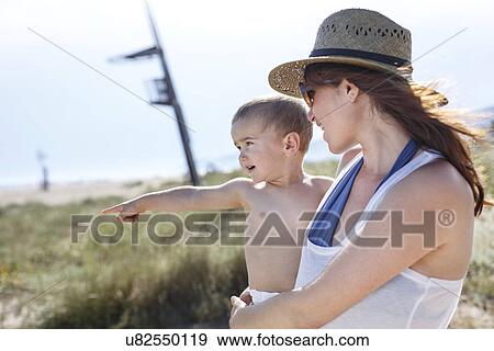 Stock Photo - Mother carrying son in arms. Fotosearch