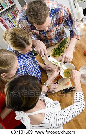 Stock Photo - Mother, daughters and son preparing food, high angle. Fotosearch