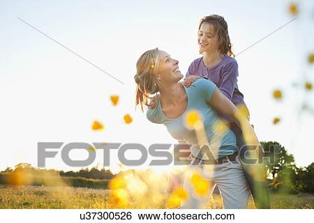 Mother giving piggy back View Large Photo Image Stock Photograph - Mother giving piggy back. Fotosearch