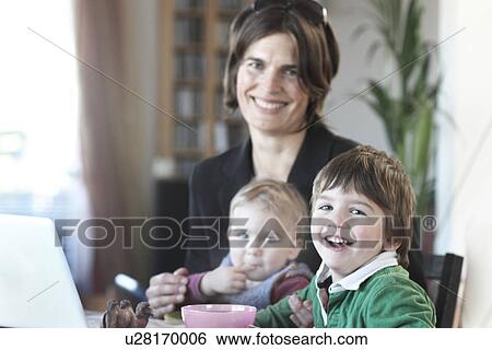 Stock Photograph - Mother having breakfast with children before work. Fotosearch