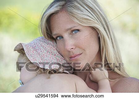 Mother hugging toddler wearing sunhat View Large Photo Image Picture - Mother hugging toddler wearing sunhat. Fotosearch