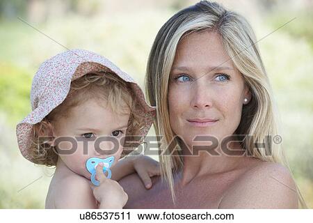 Mother hugging toddler wearing sunhat View Large Photo Image Stock Image - Mother hugging toddler wearing sunhat. Fotosearch