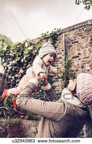 Mother throwing baby in air View Large Photo Image Stock Image - Mother throwing baby in air. Fotosearch
