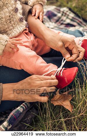 Mother tying baby booties View Large Photo Image Stock Photo - Mother tying baby booties. Fotosearch