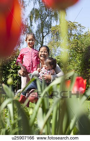 Stock Photograph - Mother with daughters in garden. Fotosearch
