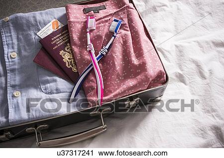 Open suitcase on bed with UK passports and pink and blue toothbrushes View Large Photo Image Stock Image - Open suitcase on bed with UK passports and pink and blue toothbrushes. Fotosearch