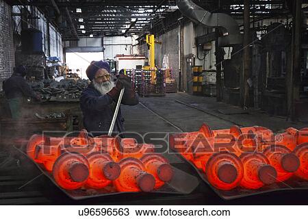 Stock Image - Operative levers still steaming drive shafts off trays in order to cool down. Fotosearch
