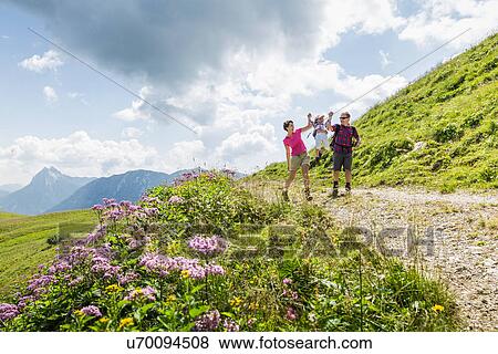 Stock Photo - Parents and daughter having fun on walk, Tyrol, Austria. Fotosearch