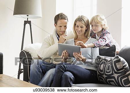 Stock Photo - Parents and son using digital tablet. Fotosearch