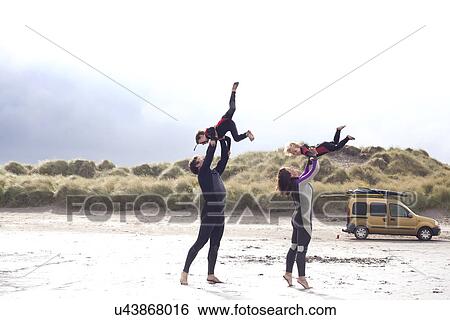 Parents lifting sons on beach View Large Photo Image Stock Photograph - Parents lifting sons on beach. Fotosearch