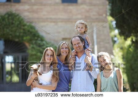 Parents standing with daughters and dog in garden View Large Photo Image Stock Photography - Parents standing with daughters and dog in garden. Fotosearch