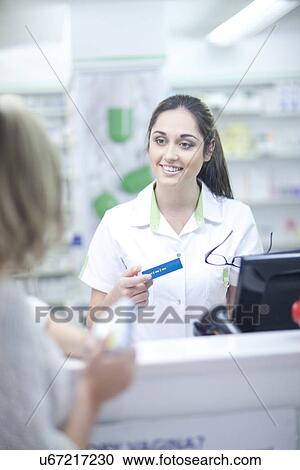 Stock Image - Pharmacist behind till. Fotosearch