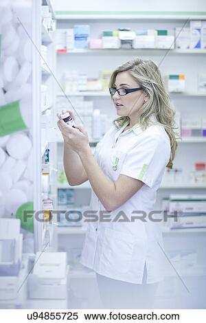 Pharmacist looking at box of medication View Large Photo Image Stock Photography - Pharmacist looking at box of medication. Fotosearch