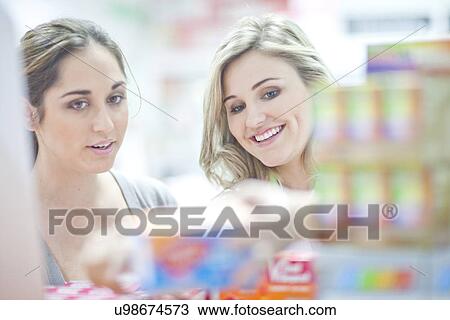 Stock Image - Pharmacist talking to customer, holding boxes of vitamins. Fotosearch