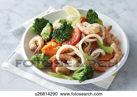 Stock Image - Plate of prawns, squid and vegetables. Fotosearch