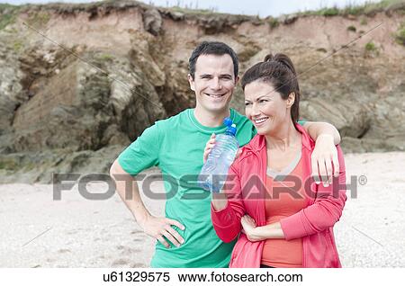 Portrait of couple on beach with water bottle View Large Photo Image Stock Photography - Portrait of couple on beach with water bottle. Fotosearch